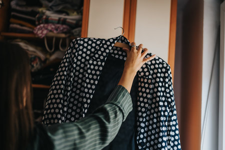 Woman selecting polka dot blazer from her closetの写真素材