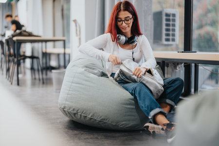 High school student relaxing on bean bag in study areaの写真素材