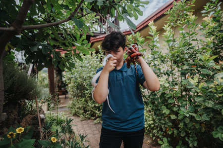 Young girl confidently holding snakes in a lush garden settingの写真素材