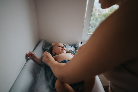 Parent bonding with baby during changing time at homeの写真素材