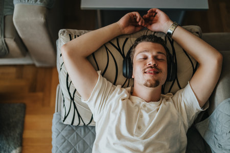 Young man relaxing on sofa with headphones onの写真素材