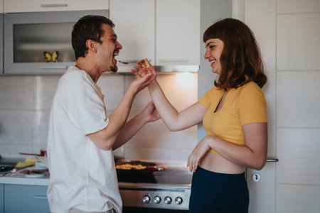 Happy couple enjoying cooking together in the kitchenの写真素材