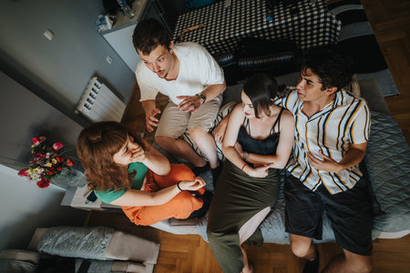 Young friends enjoying casual conversation in a cozy living room settingの写真素材