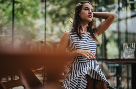 Young woman relaxing in a stylish striped summer dressの写真素材