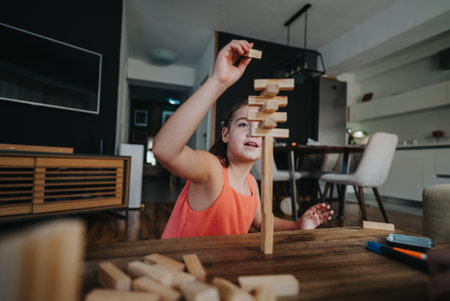 Young girl building a tall block tower in modern living roomの写真素材