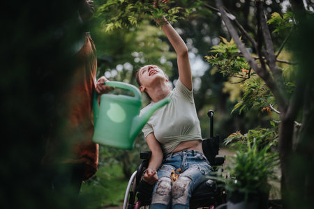 Young woman in wheelchair gardening and enjoying natureの写真素材