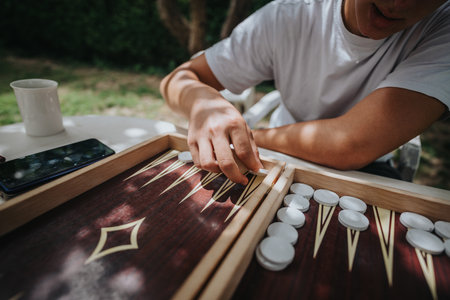 Person playing backgammon outdoors on a sunny day with a coffeeの写真素材