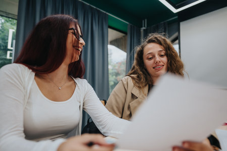Students in classroom sharing and discussing educational materialsの写真素材