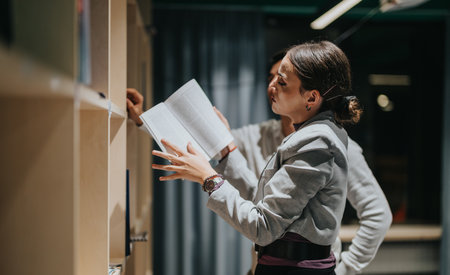 High school students reading books in a modern library settingの写真素材