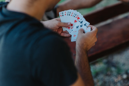 Man enjoying a casual card game at an outdoor tableの写真素材