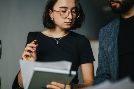 Students discussing academic materials with professor between classesの写真素材