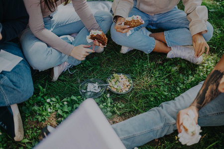 Group of students enjoying a picnic in the park togetherの写真素材