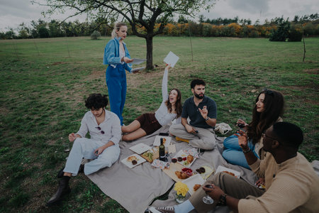 Friends enjoying a carefree picnic in a beautiful park settingの写真素材