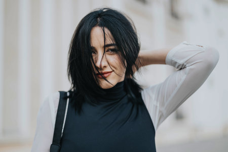 Confident woman posing in an urban street setting outdoorsの写真素材