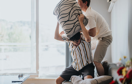 Friends having a fun pillow fight in living room