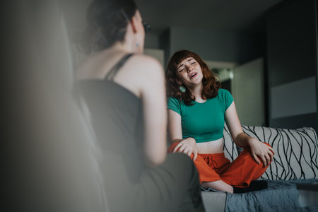 Young woman passionately singing during a casual indoor gatheringの写真素材