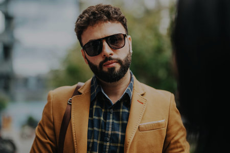Stylish man with sunglasses in outdoor business meeting settingの写真素材
