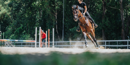 Woman riding horse during equestrian training session in outdoor arena
