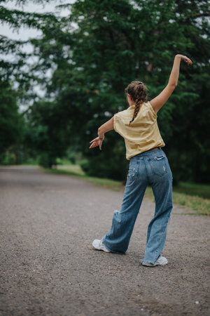 Girl having fun alone in the park, dancing and enjoying natureの写真素材