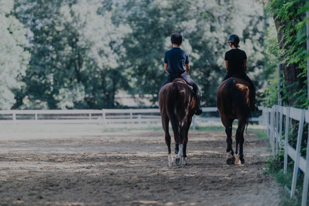 Two equestrians riding horses in a serene outdoor setting