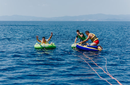 Friends enjoying speedboat tubing on a sunny day at sea