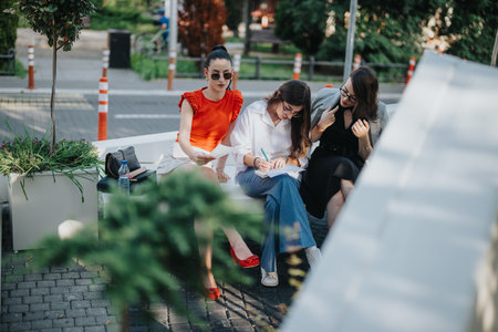Businesswomen collaborating outdoors, brainstorming ideas and working togetherの写真素材
