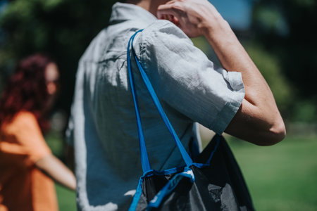 Close-up of a person carrying a reusable shopping bag outdoors in a park