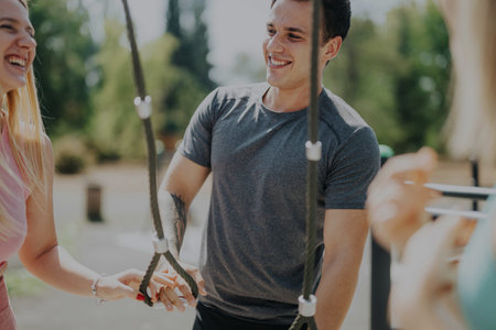Friends enjoying a fun outdoor exercise session with ropes in a sunny park setting
