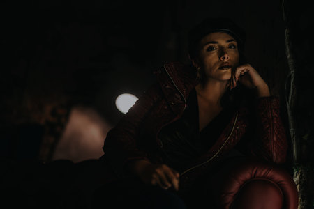 Elegant woman in dark setting with stylish leather clothing