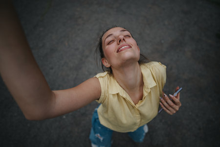 Young woman having fun alone in the park, enjoying the outdoors and taking a selfieの写真素材