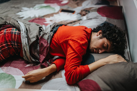 Young man sleeping comfortably on a colorful bed at home