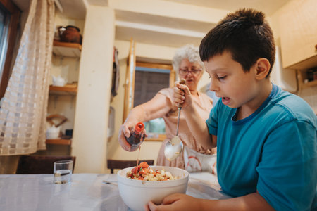Grandmother and grandson preparing a salad together in the kitchenの写真素材