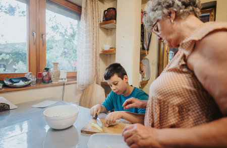 Grandmother and grandson cooking together in cozy kitchen settingの写真素材