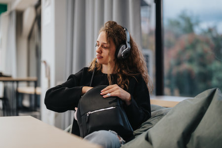High school student enjoying music with headphones in classroomの写真素材