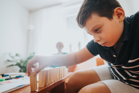 Grandmother knitting while nephew plays with building blocks at homeの写真素材