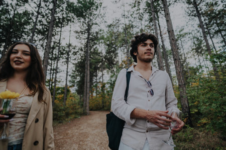 Young friends enjoying a leisurely walk in a forest settingの写真素材