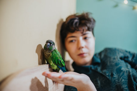 Young girl enjoying playful moment with her pet parrotの写真素材