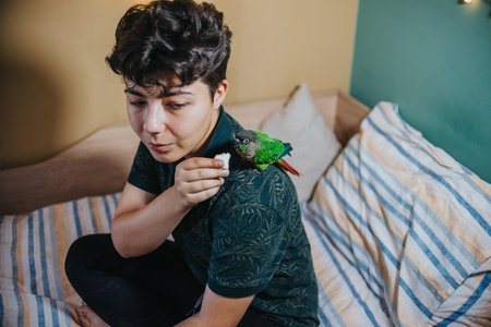 Young girl interacting with a colorful parrot on her shoulderの写真素材