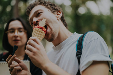 College students enjoying ice cream with their professor outdoors