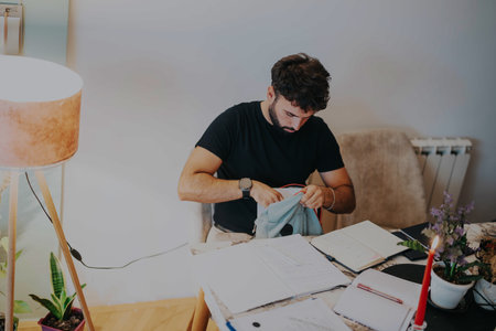 College student organizing study materials at home workspaceの写真素材
