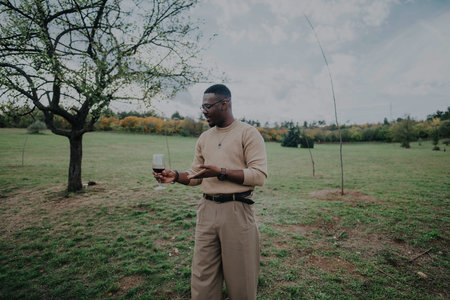 Man enjoying a glass of wine in a peaceful natural settingの写真素材