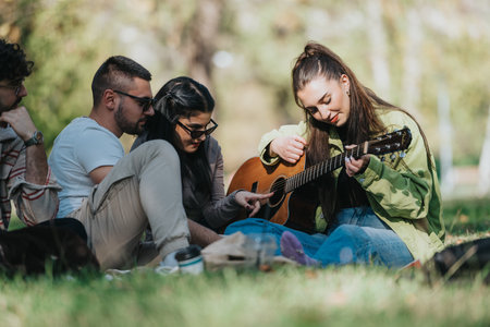 Friends enjoying an outdoor guitar jam session in a park