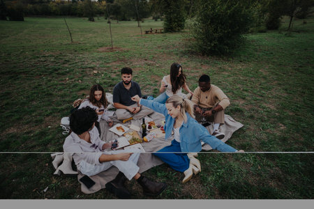 Friends enjoying a picnic in a serene outdoor settingの写真素材