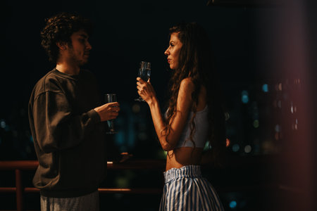Young couple enjoying a romantic evening on a city balconyの写真素材