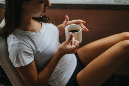 Young woman relaxing with a cup of coffee at homeの写真素材