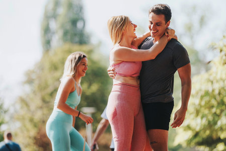 Friends enjoying a playful workout in a sunny parkの写真素材