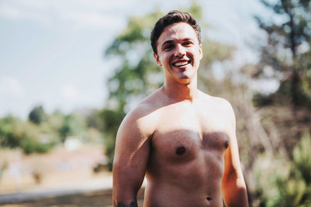 Young athletic man smiling outdoors on a sunny dayの写真素材