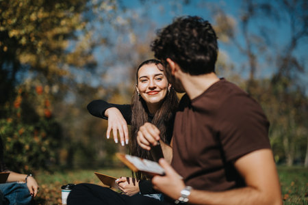 Smiling young couple enjoying a sunny day outdoors in the park, sharing a moment of laughter and connection surrounded by natures beauty in the vibrant landscape.の写真素材