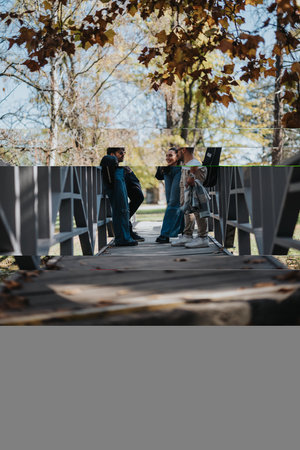 Group of friends enjoying outdoor conversation on a bridge in autumn
