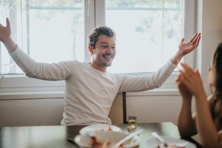 Joyful man laughing and socializing at dining tableの写真素材